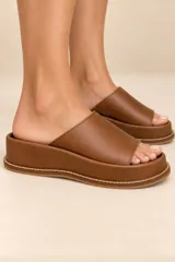 Sandalias de cuero vacuno con plataforma baja, capellada ancha de pelo con estampado animal print tipo dálmata en tonos marrón oscuro y blanco, y plantilla marrón.