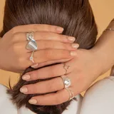 Anillo de plata 925 con diseño de superficie lisa y forma irregular, con una banda delgada.