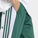 Pantalón deportivo Adidas Adibreak de corte holgado, color verde con franjas laterales blancas y las icónicas tres rayas en verde. Presenta botones a presión a lo largo de los laterales y logo de la marca en la parte inferior.