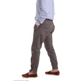 Pantalón de vestir verde oliva, de corte recto, con bolsillos laterales y traseros. Se ajusta a la cintura con cinturón de cuero marrón.