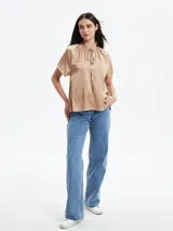 Camisa color verde oliva de mangas cortas con cuello redondo y lazo ajustable.