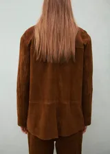 Blazer de gamuza color marrón con cierre frontal de botones, bolsillos con solapa y cuello clásico.