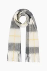 Bufanda de tejido suave y esponjoso con diseño de cuadros grandes en tonos beige, gris y amarillo, terminada con flecos en los extremos.