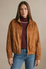 Campera tipo bomber de gamuza sintética color camel, con cierre frontal, cuello alto y diseño oversize.