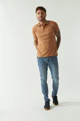 Remera polo de manga corta color tostado, con cuello clásico, cierre frontal de botones y un pequeño bolsillo en el pecho con logo estampado.