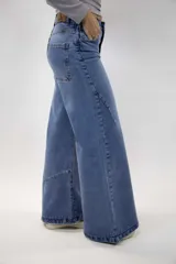 Pantalón jean baggy de color azul, con tiro medio, bolsillos traseros y diseño amplio en las piernas.