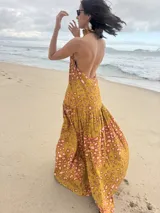 Vestido largo marrón de crepe texturizado, con cuello halter fruncido, diseño holgado y falda larga con vuelo.
