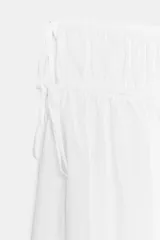 Pantalón culotte de tiro medio y corte amplio, con cintura elástica y detalles de lazadas ajustables en los laterales.