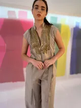 Mono largo color beige confeccionado en lino y algodón, con estampado texturizado en los laterales superiores. Presenta cuello mao, cierre invisible central, bolsillos laterales, cinto para ajustar en la cintura y tablón central delantero en las piernas.