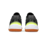 Championes Asics Gel-Task 3, diseñados para deportes de interior. Presentan un diseño en color negro con detalles en blanco y toques de amarillo neón en el talón. Cuentan con una suela de goma color caramelo, ideal para superficies de cancha, y el logo de la marca en los laterales.