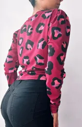 Remera de manga larga color borra de vino con estampado animal print en negro, rosa y lila. Tiene un nudo en la parte delantera.