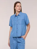 Camisa de corte recto y calce fluido color celeste, confeccionada en lyocell, con cuello camisero clásico, mangas cortas y bolsillos plaqué en el pecho.