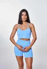 Conjunto deportivo de dos piezas compuesto por un top de tirantes finos con logo estampado y un short de tiro alto, confeccionado en tejido seamless de textura acanalada.