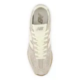 Championes New Balance modelo U471RB, color beige con detalles en blanco, confeccionados en gamuza y malla, con logo "N" característico en los laterales y suela de goma color caramelo.