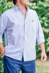 Camisa blanca de manga larga, de corte clásico y holgado, confeccionada en algodón con botones de madera.