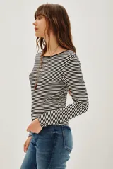 Remera de manga larga con diseño de rayas horizontales finas en blanco y negro, confeccionada en tejido suave y elástico.