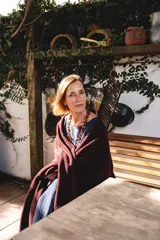 Ruana de lana en color bordó, con diseño de corte en picos en la espalda y terminación con flecos. Es una prenda versátil de talle único, ideal para complementar tanto looks casuales como formales.