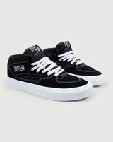 Championes de skate Vans modelo Half Cab, de corte medio, confeccionados en gamuza y lona color negro con costuras blancas. Presentan suela de goma blanca vulcanizada, cordones blancos y etiqueta distintiva en el lateral y la lengüeta.