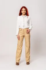 Pantalón de tiro alto color beige con estampado difuminado, bolsillos laterales y cierre frontal con cremallera y botón.