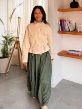 Campera de estilo safari en color beige, confeccionada en material tipo napa. Presenta cuello alto, cierre frontal con botones metálicos, bolsillos frontales con solapa y detalles de trabillas en los puños.