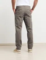 Pantalón de gabardina de corte recto y tiro medio, con bolsillos laterales y traseros, y cierre frontal con botón y cremallera.
