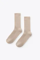 Par de calcetines de caña media, color beige claro, con textura acanalada (rib).