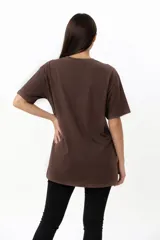 Remera de algodón de corte holgado, color beige con estampado botánico en color verde oliva y texto en el frente.