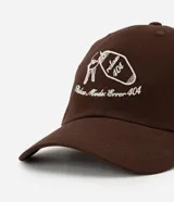 Gorra de béisbol color marrón oscuro con visera curva y bordado frontal en hilo blanco que incluye un llavero con llaves y el texto "Relax Mode Error 404".
