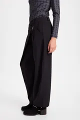 Pantalon de corte amplio y tiro alto con diseño cruzado en la cintura y cierre frontal con boton. Presenta una silueta fluida y relajada.