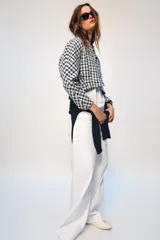 Chaqueta corta de Zara Woman Collection confeccionada en tejido de algodón con estampado de cuadros en tonos blanco, azul y negro. Presenta escote en pico, manga larga y cierre frontal con botones oscuros.