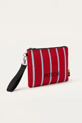 Necessaire tipo pouch confeccionado en neopreno, con diseño de rayas rojas y celestes, cierre superior y correa de mano desmontable en color negro. Cuenta con el logotipo de la marca bordado en el frente.