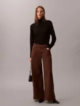 Pantalón chino de pierna súper ancha color marrón, tiro alto, con diseño de cinco bolsillos, cierre de botón y cremallera, y detalles distintivos de la marca Calvin Klein.