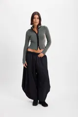 Campera corta de tejido de punto acanalado con diseño de rayas verticales en dos tonos. Presenta cuello alto y cierre frontal completo con borde en color negro.