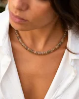 Collar corto de cuentas facetadas en tonos beige y marrones, con diseño tipo donut. Cuenta con cierre de acero.