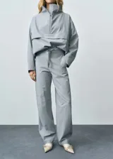 Pantalón de vestir estilo jogger con tiro medio, bolsillos laterales y cierre oculto. Presenta un diseño largo de corte recto y forro interior.