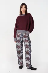 Pantalon de pierna recta con estampado tipo patchwork en tonos azul, bordó y blanco. Cuenta con cintura ajustable con elástico y cordón, dos bolsillos laterales redondeados y dos bolsillos traseros tipo plaqué.