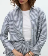 Camisa de jeans de manga larga con estampa de rayas verticales en tonos azul y blanco, cuello inglés, cierre frontal por botones y bolsillos grandes en el frente.