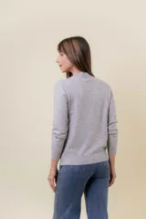 Buzo de tejido fino color amarillo claro, con cuello semi alto, manga larga y calce regular.