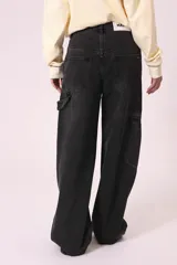 Pantalón de jean negro de corte ancho, con bolsillos laterales y traseros.