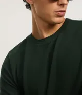 Remera de corte regular confeccionada en tejido piqué de algodón, con cuello redondo y manga corta. Presenta un diseño liso y minimalista con textura sutil.