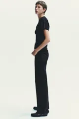 Jeans de tiro alto y estilo wide leg, con diseño de cinco bolsillos, lavado oscuro con efecto desgastado, pierna ancha larga y bajo sin costuras.