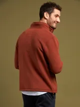 Campera de poliéster color ladrillo con cierre frontal, cuello alto y bolsillos laterales.