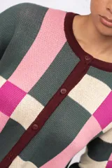 Saco de punto con diseño geométrico de cuadros en tonos verde, rosa, fucsia y crema. Presenta cuello redondo, cierre frontal con botones y terminaciones en color bordó.