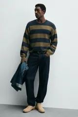 Bota estilo Chelsea de piel con acabado serraje color beige, con elásticos laterales para facilitar el calce, horma redonda y suela a tono con ligero tacón.