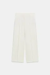 Pantalón cropped de tiro medio color blanco, perteneciente a la colección ZW Collection, con cintura con trabillas, bolsillos laterales ocultos, pinzas en el delantero, pierna ancha y cierre frontal con cremallera, botón y ganchos metálicos.