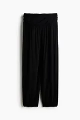 Pantalón de corte holgado en punto de viscosa, de color negro, con cintura elástica ancha fruncida y piernas estilo globo con puños elásticos en los tobillos.