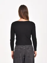 Remera de manga larga con diseño de rayas horizontales en blanco y negro, cuello redondo y ajuste al cuerpo.