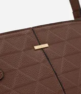 Cartera bandolera mediana de color marrón, confeccionada en poliuretano con textura tipo floater. Presenta un diseño rectangular con costuras geométricas, herrajes metálicos dorados y correas laterales decorativas. Incluye cierre superior con cremallera y correa larga ajustable.