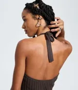 Vestido sin mangas, color marrón oscuro, con escote tipo halter y lazo en el cuello. El tejido es de malla con efecto tricot texturizado acanalado.