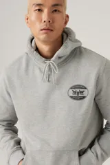 Hoodie gris melange con capucha y bolsillo canguro frontal. Presenta un parche ovalado negro con el logo de dos caballos tirando de un pantalón, característico de Levi's.